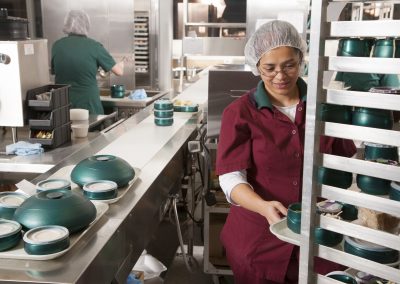 Food worker in commercial kitchen preparing meal